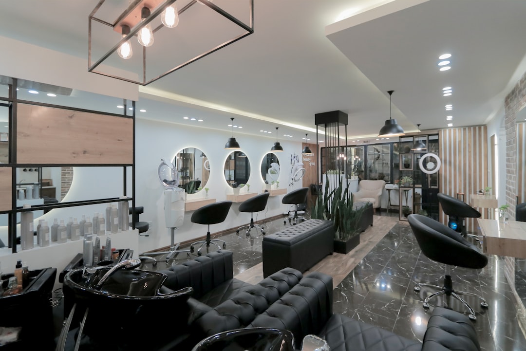 Modern, stylish hair and beauty salon interior with plush wash basins, backlit circular mirrors, and styling stations, representing web design for aesthetics and salon businesses.